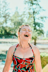 Wall Mural - laughing emotional blonde woman with wet hair making water splashes. Holidays, happiness, fun, summer, leisure concept