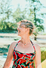 Wall Mural - laughing emotional blonde woman with wet hair making water splashes. Holidays, happiness, fun, summer, leisure concept