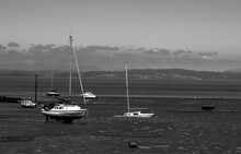 Black And White Photo Of Stuck Boats At Low Tide