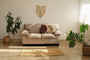 Minimalistic image, beige textile couch with round cushions over the blank wall background with a lot of copy space for text. Empty room interior with just a single sofa. Close up.