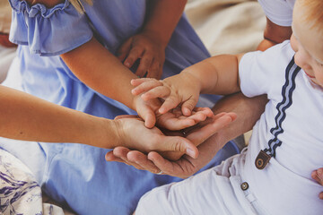 Family is together, father, mother, daughter, son support each other. Hands close-up.