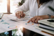 © Natee Meepian - business woman working on desk office with calculator to calculate the numbers, finance accounting concept