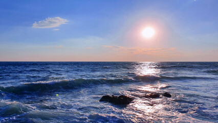 Wall Mural - colorful sunset with large sun under the sea waves.