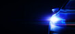 Car headlights with light rays and copy space, banner. Light of blue car headlights on a dark background, panorama