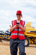 © ADDICTIVE STOCK - Smiling woman having phone call near combine harvester