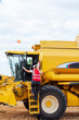 © ADDICTIVE STOCK - Anonymous woman getting into combine harvester
