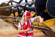© ADDICTIVE STOCK - Smiling woman having phone call near combine harvester