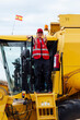 © ADDICTIVE STOCK - Smiling oman standing in combine harvester