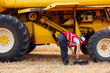 © ADDICTIVE STOCK - Happy smiling woman checking combine harvester