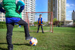 © pahis - Little preschool boys friends playing soccer football on playground grass field outside. Happy authentic candid childhood lifestyle. Seasonal summer outdoor activity with ball for kids