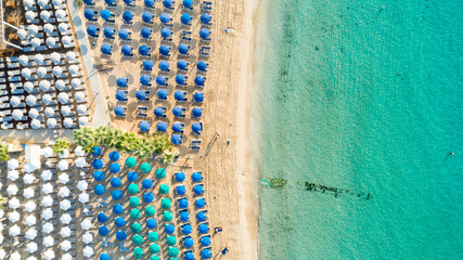 Wall Mural - Aerial above bird's eye view of Pantachou - Limanaki organised beach (Kaliva), Ayia Napa, Famagusta, Cyprus. Blue aligned umbrellas, golden sand, parasols, sunbathing sea beds clean turquoise water	
