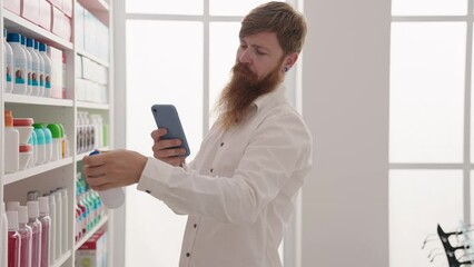 Wall Mural - Young redhead man customer using smartphone at pharmacy