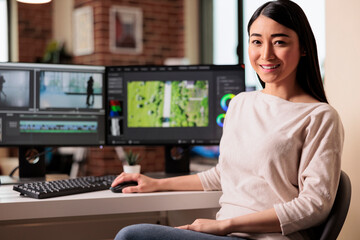 Portrait of female videographer editing movie footage on computer, working on creative software with multimedia montage. Using post production panel creating visual effects film content.