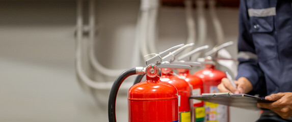 engineer are checking and inspection a fire extinguishers tank in the fire control room for safety t