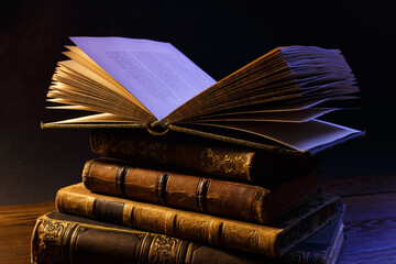 Wall Mural -  Old open book on a stack of ancient books