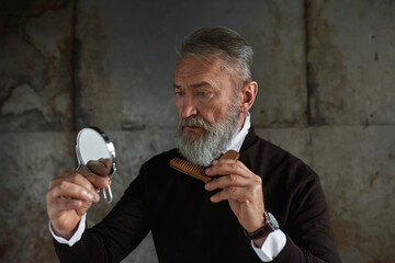 Wall Mural - Caucasian man looking at camera of combing beard