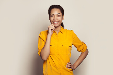 Wall Mural - Young african american woman in casual yellow shirt laughing on white background