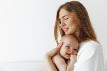 caring mother hugged her little daughter, pressing her to her chest. woman holding a newborn baby in her arms at home