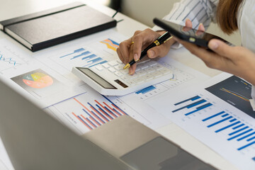 A businessman holding a smartphone working on project statistics on the device is ready. Graph presentation, notebook, entrepreneur, financial market data analysis. that represents a change