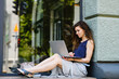© o_lypa - Young attractive woman with laptop sits on the windowsill outdoors.