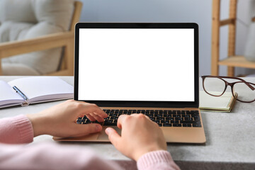 Woman working on laptop at white table, closeup. Mockup for design