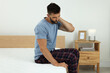 © New Africa - Man suffering from neck pain after sleeping on uncomfortable mattress at home