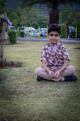 Wall Mural - boy sitting on the grass in a park