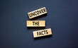 Uncover the facts symbol. Concept words Uncover the facts on wooden blocks on a beautiful black table black background. Business and uncover the facts concept. Copy space.
