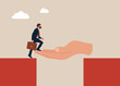 © Vadym - God hand reach to help or recuse entrepreneur cross the cliffs. Solve business problemHelping hand support in career development.
