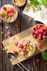Poster - Healthy breakfast menu concept. Home made granola breakfast. Glass of parfait made of granola, berries raspberry, yogurt with chia seeds on rustic table. View from above.