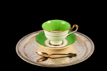 Cup and saucer of fine bone china on a silver tray.