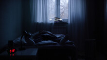 View Of A Man At Night Suffering From Deep Depression. Lonely Man Lying On The Bed In The Dark