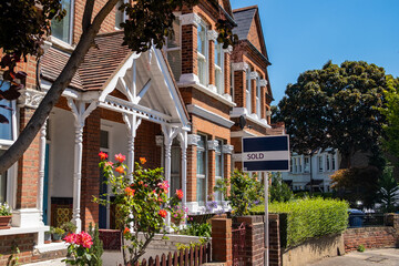 Wall Mural - House Sold sign on attractive street of residential British houses 