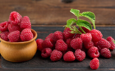 Wall Mural - Ripe red raspberries on a brown wooden board