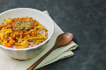 Wall Mural - Korean food Bibimbap, Rice topped with sautéed beef and a variety of colorful vegetables that is mixed at the table with spicy gochujang. A hint of sesame oil helps bring out the flavor.