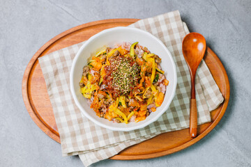 Wall Mural - Korean food Bibimbap, Rice topped with sautéed beef and a variety of colorful vegetables that is mixed at the table with spicy gochujang. A hint of sesame oil helps bring out the flavor.