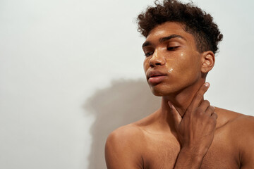 Thoughtful black guy with golden mask on his face