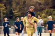 © Drazen - Playful goalkeeper piggybacking her teammate on playing field.