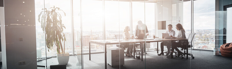 Wall Mural - Team of businessmen communicating together after meeting in office with panoramic windows.