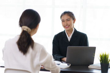 Wall Mural - Two young Asian businesswomen discuss the concept of a new start-up project. Analyze marketing planning and financial statement at the office.