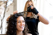 © carles - Hairdresser curling the hair of a smiley client