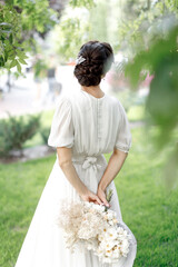 Wall Mural - Bride in wedding dress posing in the garden