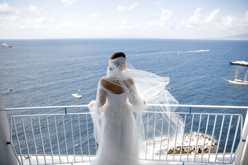 Wall Mural - Bride in wedding dress posing on the balcony