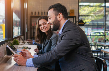 young business people casual working at coffee bar by glass window , happy businessman and businesswoman meeting and brainstorming together in the coffee shop in the city