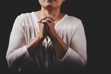 christian woman hand on holy bible are pray and worship for thank god in church with black background, concept for faith, spirituality and religion