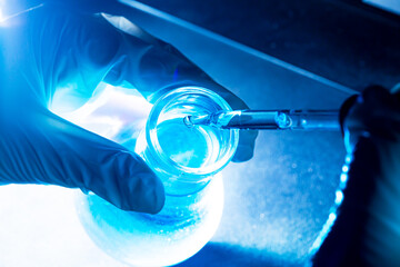 Flask in scientist hand with test tubes 