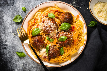 Wall Mural - Pasta with Meatballs in tomato sauce, basil and parmesan on dark stone table. Top view with copy space.