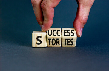 Success stories symbol. Concept words Success stories on wooden cubes. Businessman hand. Beautiful grey table grey background. Business and Success stories concept. Copy space.