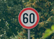 Selective Focus Shot Of A Maximum Speed Limit 60 Street Sign With Trees In The Background