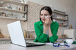© Liubomir - Online consultation with a family psychologist, a young beautiful woman in the kitchen cries in depression, uses a laptop for a video call, consults with a psychotherapist
